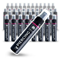 Piercingsuihke Laatikko 40 x 60ml Wildcatilta Useita mustia suihkepulloja, joissa on Wildcat-logo ja teksti Lävistyksen hoito valkoisella taustalla
