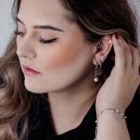 Tyylikkäät Chunky Pearl Hoops mustana ja hopeana Nainen tyylikkäissä mustissa ja hopeisissa Chunky Pearl Hoops -korvakoruissa ja muissa korvakoruissa