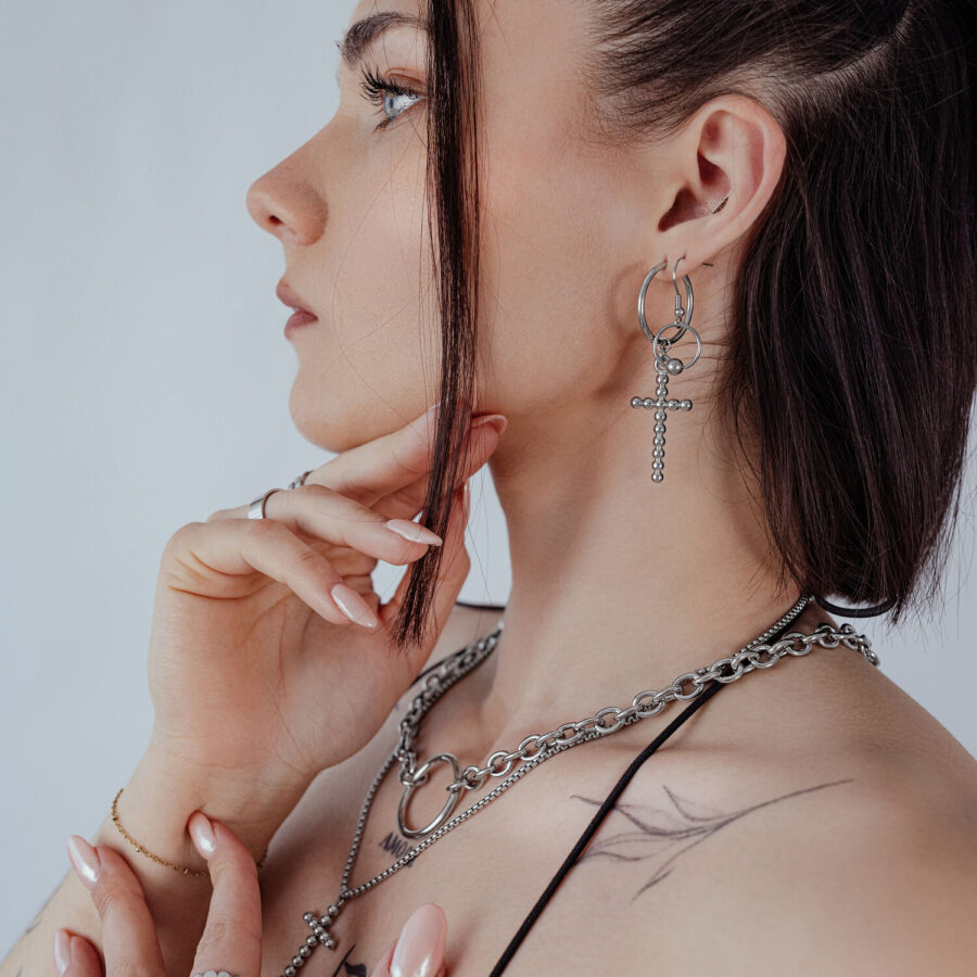Nainen, jolla on hopeiset Bubble Cross Hoops -korvakorut korvassa, sivuprofiili