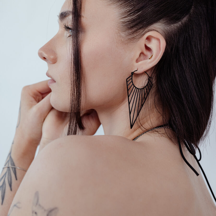 Mustat Prisma Hoops korvakorut ruskeahiuksisella naisella, sivulta kuvattuna