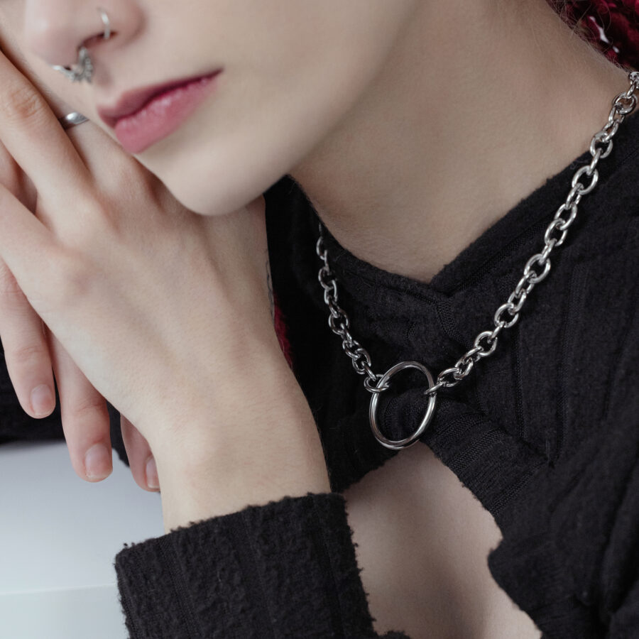 Unisex O-kaulakoru mustasta ja hopeisesta kirurginteräksestä henkilön yllä