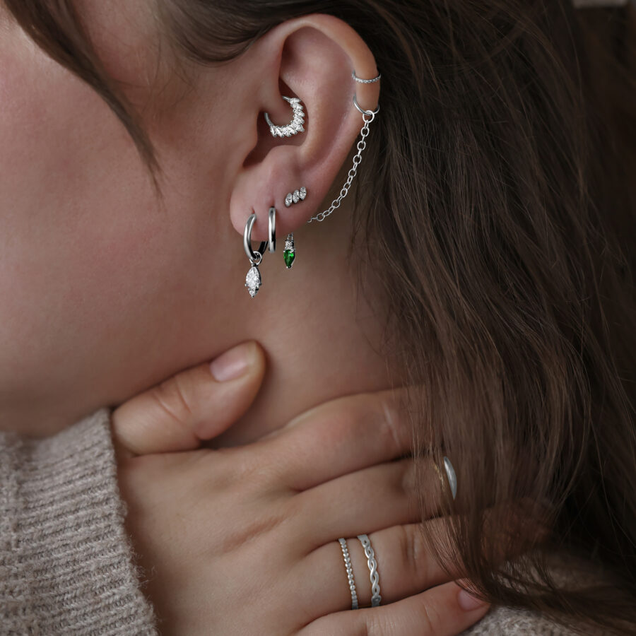 Nainen käyttää Little Tear Hoops -korvakoruja kirurginteräksestä eri väreissä ja ko'oissa.