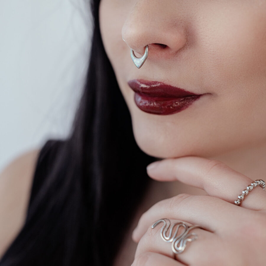 Nainen hopeisella septum clickerilla ja punaisilla huulilla