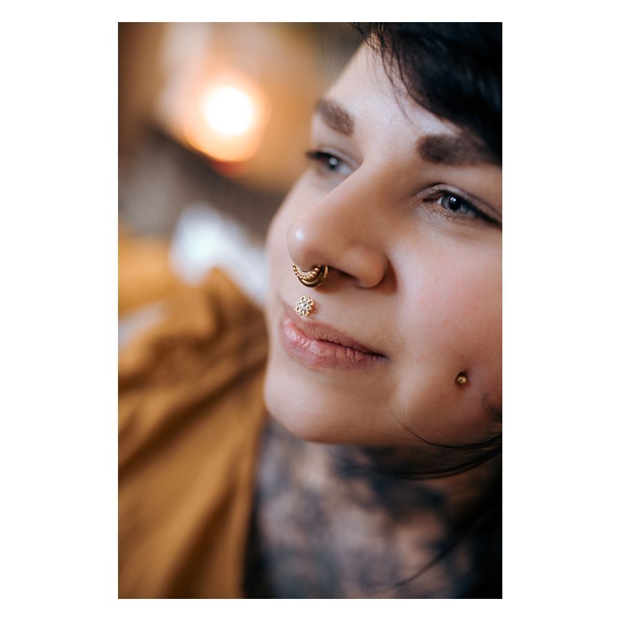 Lähikuva henkilöstä, jolla on Oriental Sun Push-Fit Labret nenälävistyksessä, kultainen väri