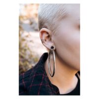 Musta Hollowed Hoops korvassa Lähikuva korvasta, jossa on suuret mustat Hollowed Hoops Wildcatilta
