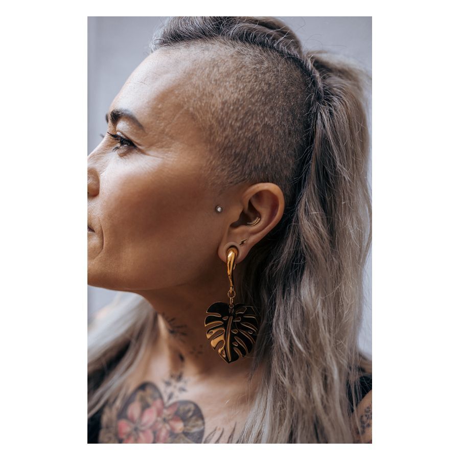 Henkilö, jolla on kultainen Flash Earbarbell korvassa, sivukuva