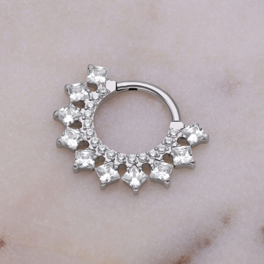 Hopeinen septum clicker kristalleilla marmoritaustalla