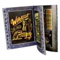 Avoin kirja, jossa Wildcat Rock'n'Roll -grafiikka ja Voodoo-design