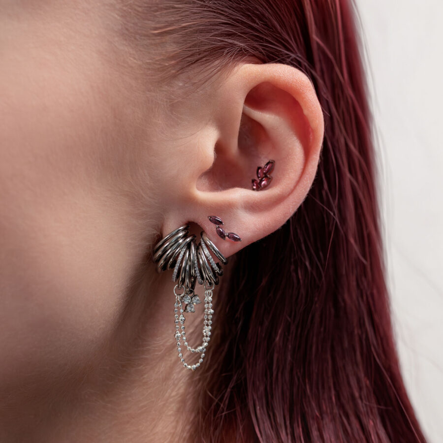 Korva, jossa hopeinen titaani-piercing ja ametistikiviä, sivunäkymä