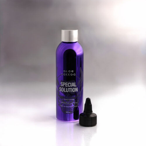 Violetti Aloe Tattoo Special Solution -pullo mustalla korkilla valkoisella taustalla