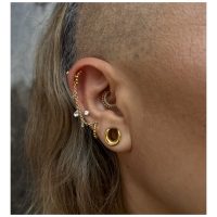 14K kultainen septum-clicker kristalleilla Korvakoru 14K kultaisella clickerilla ja kirkkailla kristalleilla, sivulta kuvattuna