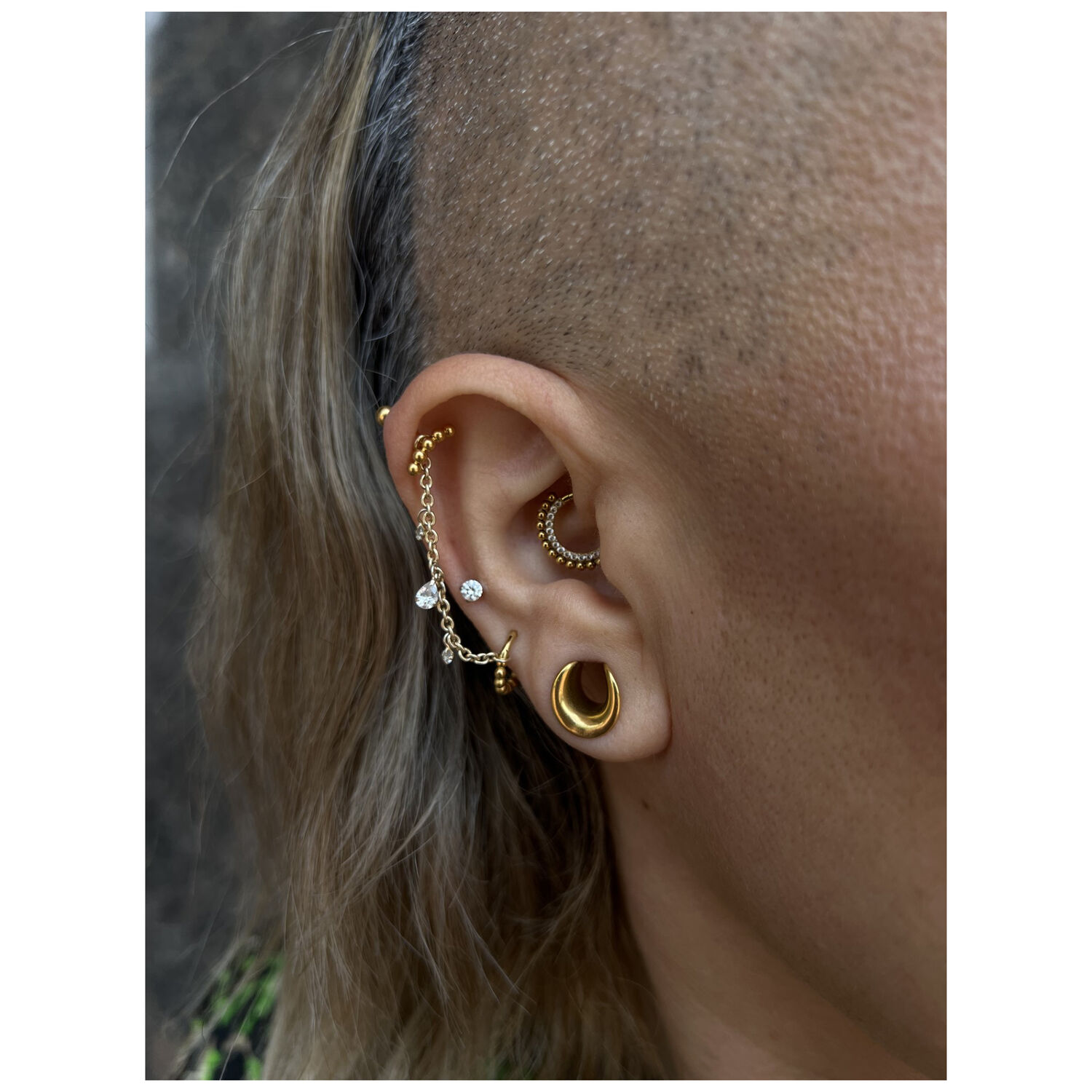 Kristallipiercingketju kullassa ja hopeassa Korva kultaisella ja hopeisella piercingketjulla, kirkas kristalli