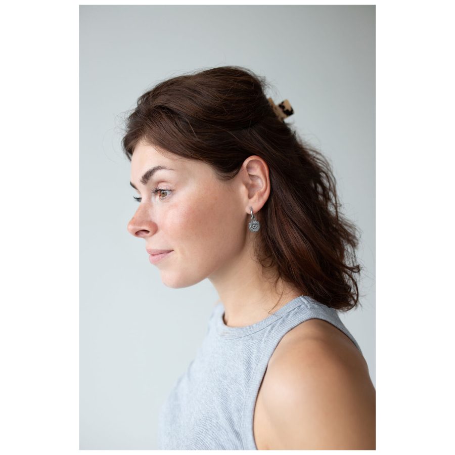 Nainen ruskeilla hiuksilla käyttää Little Luminous Eye Hoops -korvakoruja, sivukuva