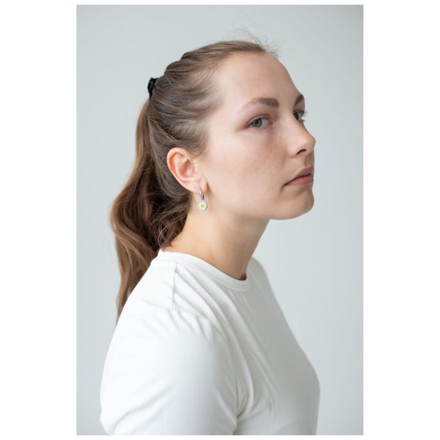 Pitkähiuksinen nainen käyttää Little Daisy Hoops -korvakoruja