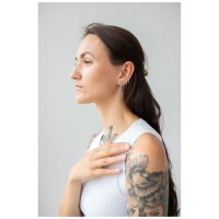 Pitkähiuksinen nainen käyttää Little Square Crystal Hoops -korvakoruja hopeassa