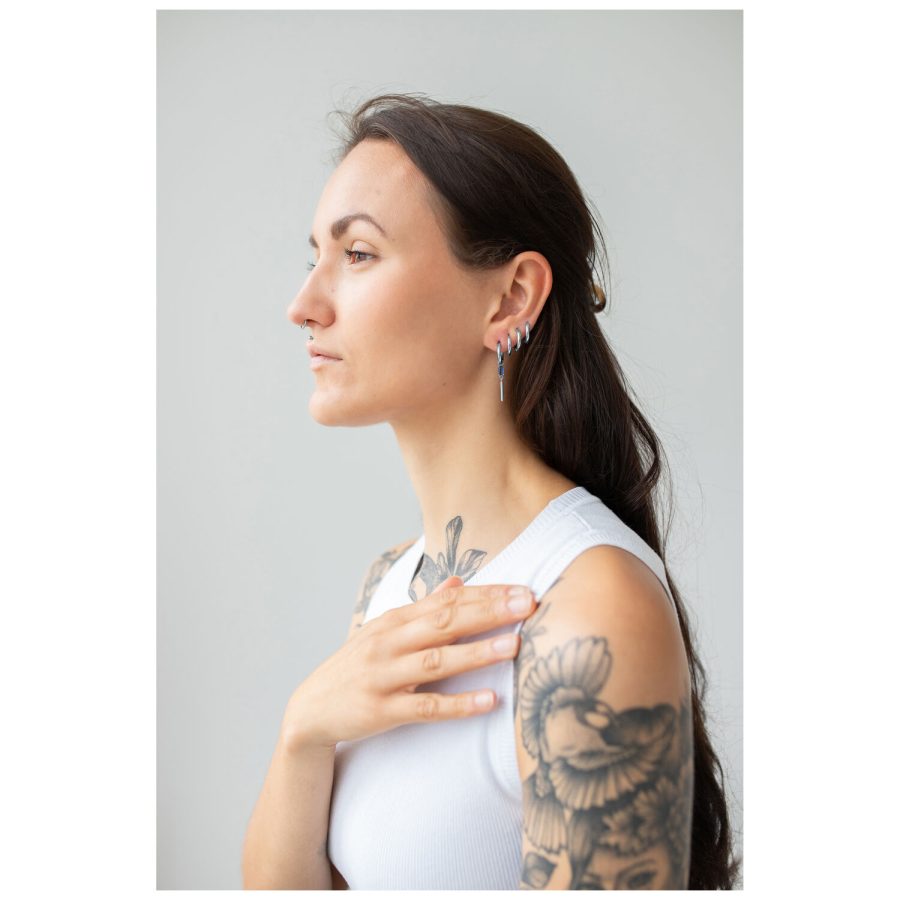 Pitkähiuksinen nainen käyttää Little Square Crystal Hoops -korvakoruja hopeassa