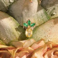 Kultainen ananas-piercingkoriste, jossa kolme vihreää lehteä ananaskuoressa