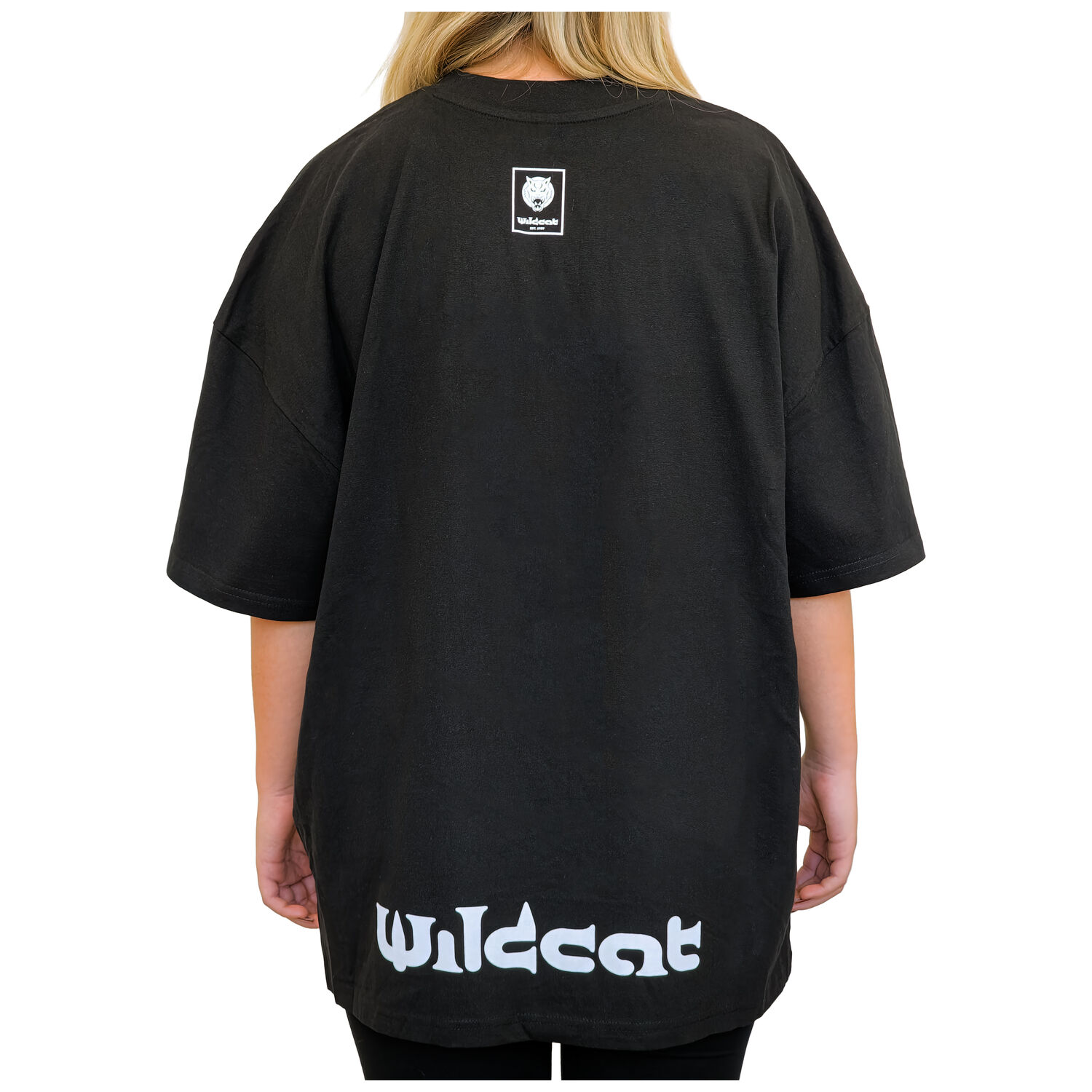 Henkilö pukeutuneena Wildcatin mustaan oversized mock neck T-paitaan, takaapäin