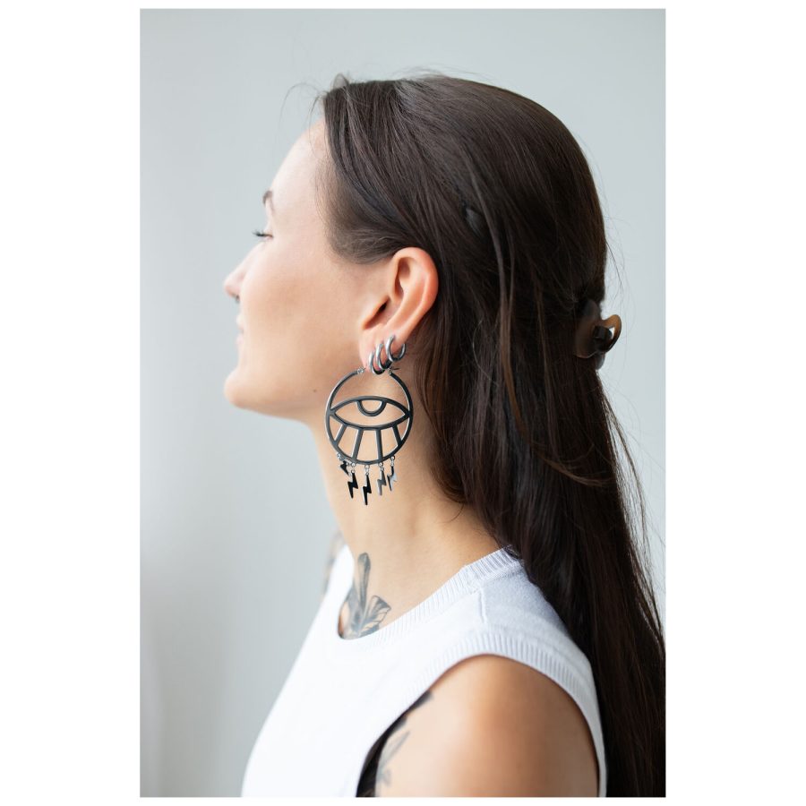Pitkähiuksinen nainen käyttää suuria mustia Thunderflash Eye Hoops -korvakoruja sivulta