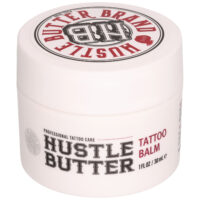 Valkoinen purkki Hustle Butter Tattoo Balsamia, jossa on punainen ja musta teksti valkoisella taustalla